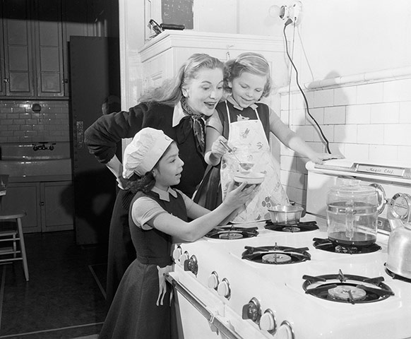 Joan Fontaine in pictures: Joan Fontaine cooks dinner with her daughters, circa 1955