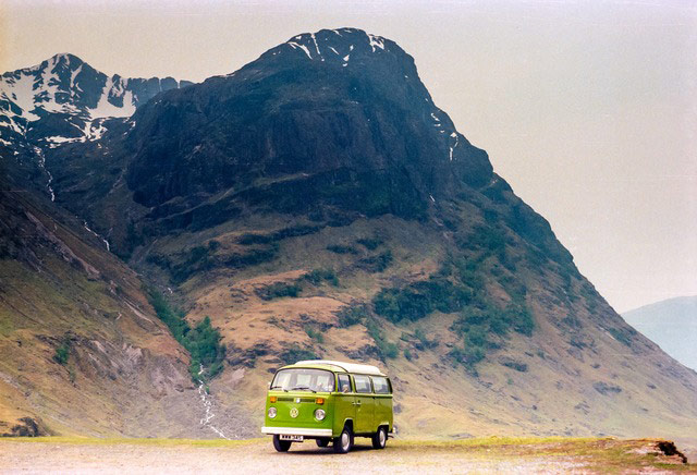 VW camper vans: green VW camper in front of mountains