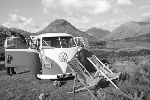 VW camper vans: VW camper and deck chairs in front of lake