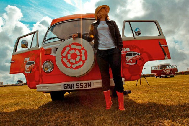 VW camper vans: woman in front of brightly coloured VW camper van