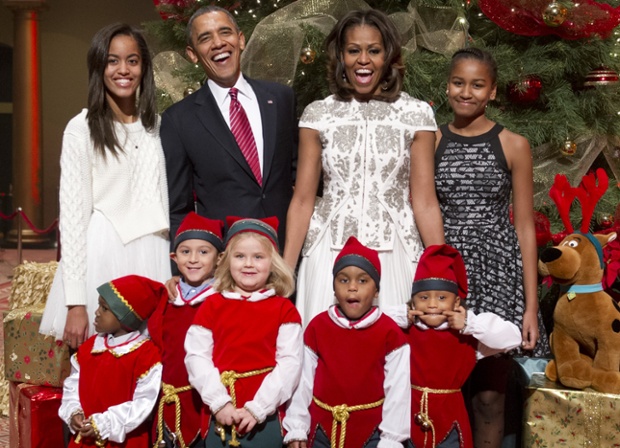 A little elf steals the show in this festive photo of  President Barack Obama, First Lady Michelle and their daughters Malia, left and Sasha, right with children who are or were patients at the Children's National Medical Center at a Christmas charity event at the National Building Museum in Washington.