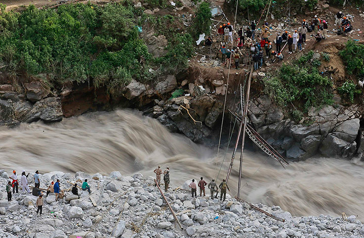 Extreme weather: Soldiers try to repair a temporary footbridge over River Alaknanda