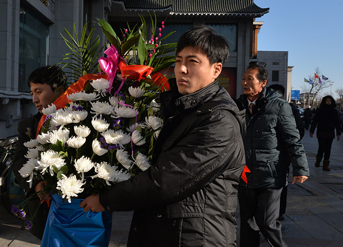 North Korea anniversary: North Koreans carry flowers as they arrive at the North Korean Consulate in