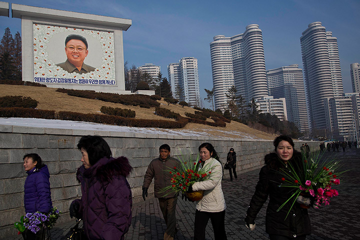 North Korea anniversary: North Koreans carry bouquets of flowers as they arrive to pay their respect
