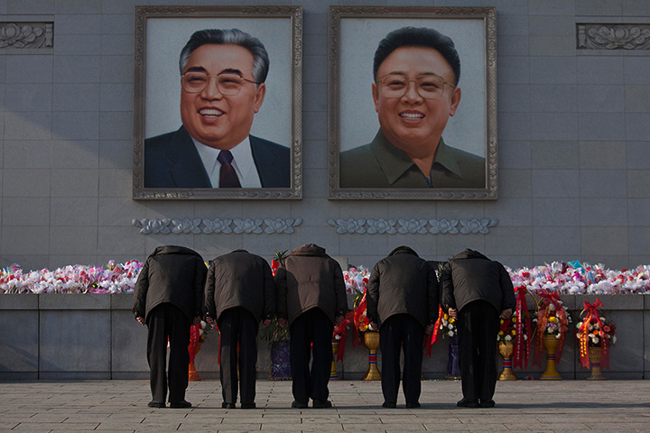 North Korea anniversary: North Koreans bow beneath portraits of the late leaders Kim Jong Il and Kim
