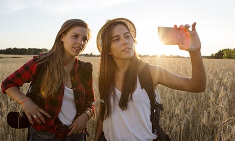 girls posing for selfie with mobile