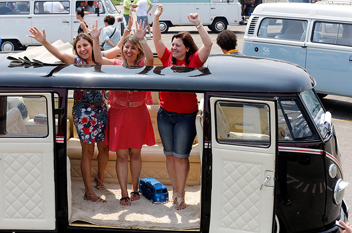 Volkswagen campers: Visitors cheer inside a Volkswagen Kombi minibus 