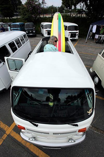 Volkswagen campers: A man arranges his surfboard inside his Volkswagen 