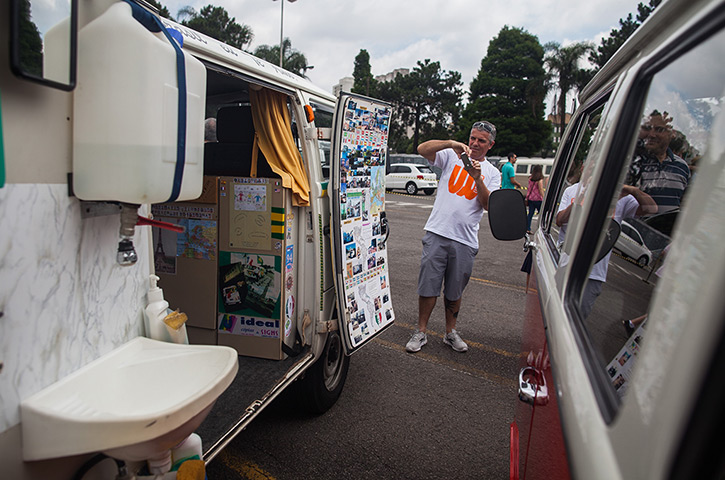 Volkswagen campers: A man takes a photograph of the inside of a van 