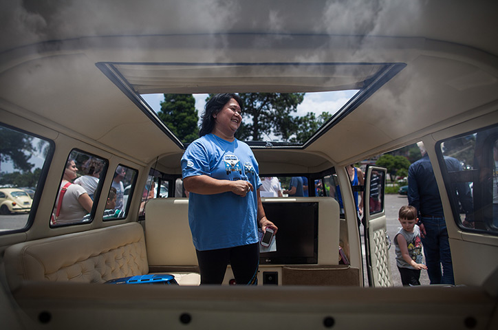 Volkswagen campers: A woman checks out the interior of a custom built Volkswagen Kombi minibus