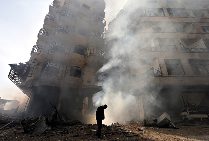 Goran Tomasevic: A building burns after a Syrian Air force air strike in the Ain Tarma neigh