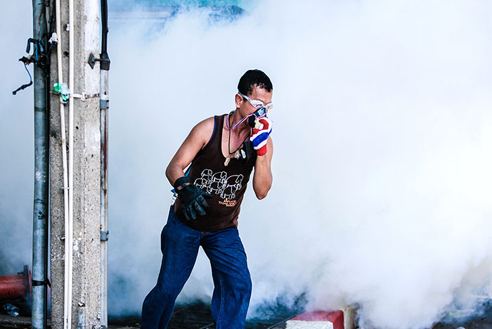 Thailand update: A protester runs away from a cloud of tear gas