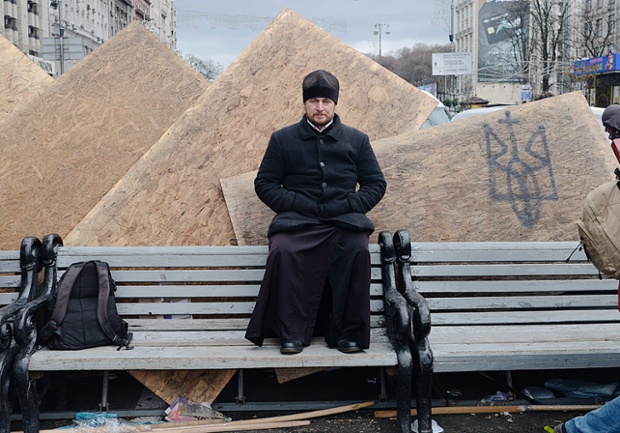 An Orthodox Priest is photographed against a barricade erected in Independent Square in Kiev, Ukraine. More than three thousand protesters spent a night out on the main square of the Ukrainian capital calling for the resignation of President Viktor Yanukovych over his decision to suspend a partnership and trade agreement with the European Union.