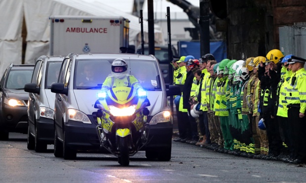 This poignant scene shows members of the emergency services forming a guard of honour as a private ambulance leaves carrying one of the victims from the Clutha Vaults pub in Glasgow following the Police helicopter crash on Friday night.