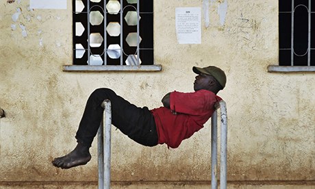 A man rests between two bars at a stadium in Mali's capital Bamako