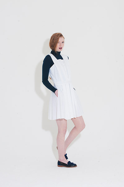 All Ages pleats: black polo neck white pinafore dress black loafers 