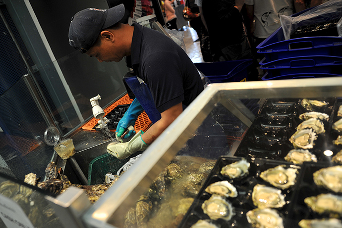 Fish Market: A worker shucks oysters 