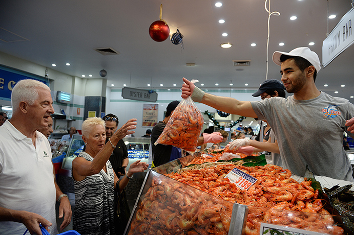 Fish Market: A fish market worker packs prawns for customers 