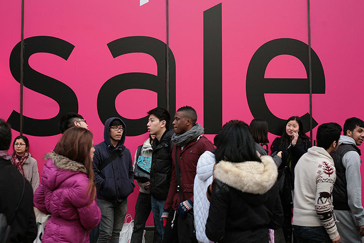 Boxing Day Sales Update: Shoppers in front of a huge sale hoarding in London