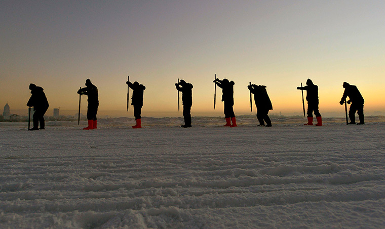 10 photo highlights: Workers on the frozen Songhua River gather ice to make sculptures
