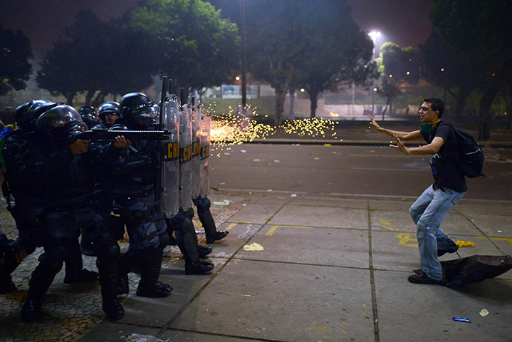 20 Photos: A protestor is shot by rubber bullets by anti-riot police officers in Rio