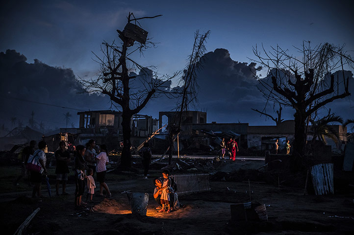 20 Photos: A family around the grave of a relative killed when Typhoon Haiyan struck