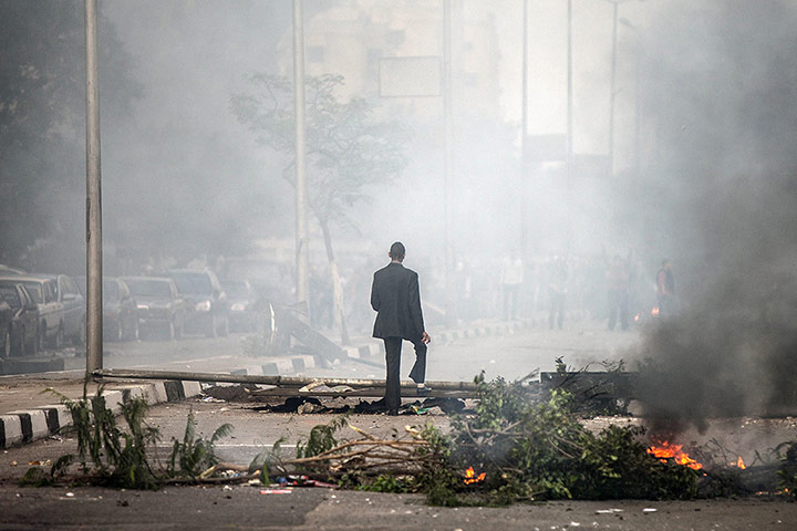 20 Photos: An Egyptian man walks through smoke during clashes in Cairo