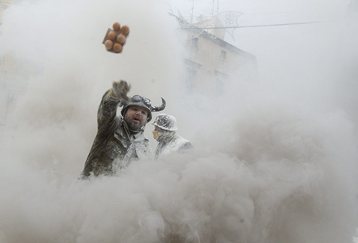 Flour festival: A reveler, dressed in a mock military dr
