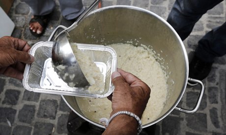 A man receives a food portion at a soup kitchen in Athens