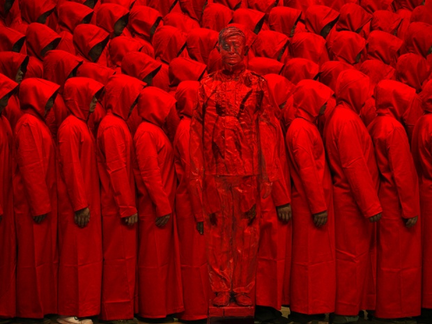 Liu stands in front of people dressed entirely in red in his studio for a piece he calls 'Red' by Liu Bolin in Beijing, China. He chose red as he feels it has deep roots in China's history.