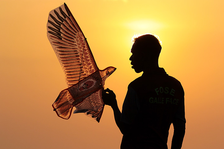 Photo highlights: Colombo, Sri Lanka: A kite seller is silhouetted during sundown on New Year