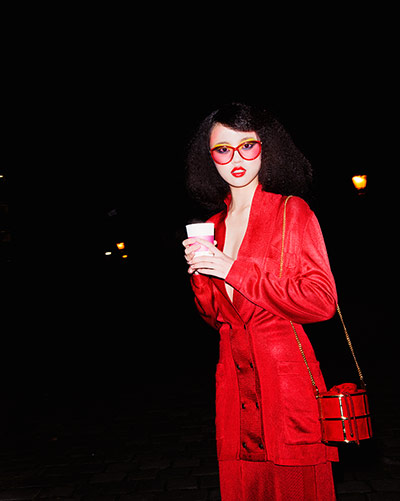 Fashion - Neon nights: Model wearing red outfit holding drink 