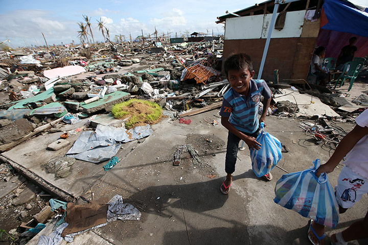 Joshua Cator: Joshua carries a bag of relief goods outside his relatives' makeshift house