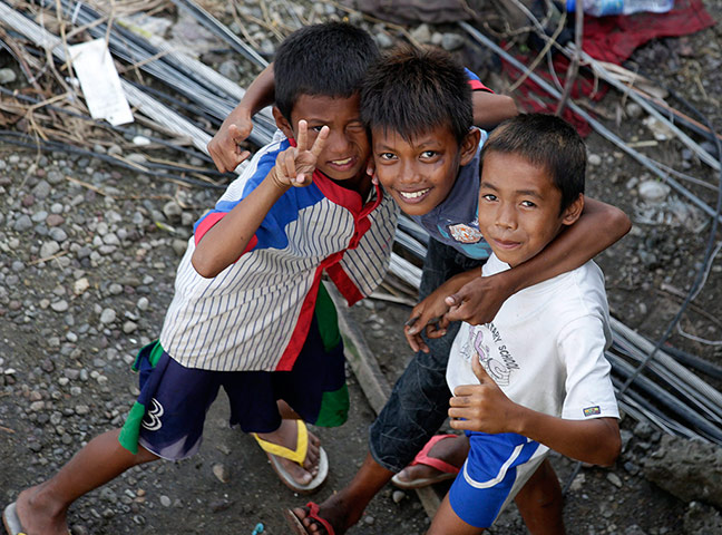 Joshua Cator: Joshua smiles with his friends while waiting for relief goods distribution