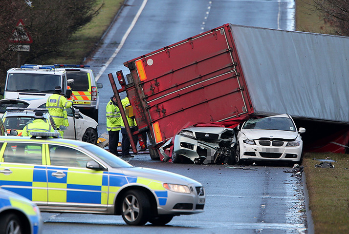 Weather update: Police at the scene where a lorry toppled on to a number of cars on the A80