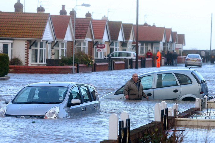 Weather updated: A man walks through the floods in Rhyl 