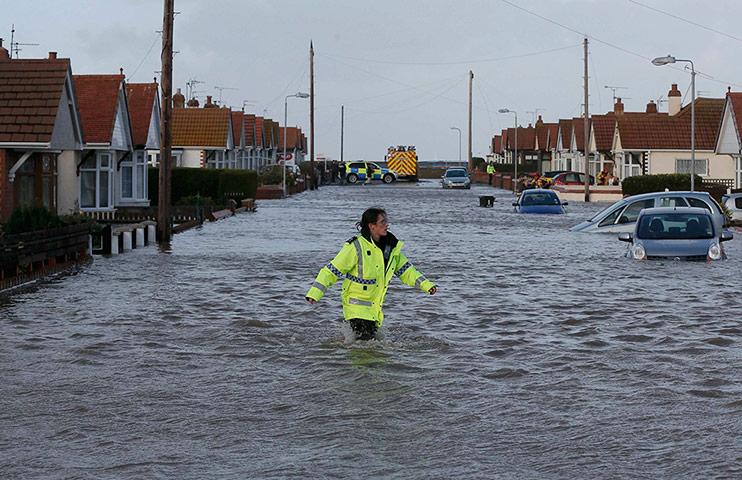 Weather gallery update: A rescue worker walks through flood water in Rhyl
