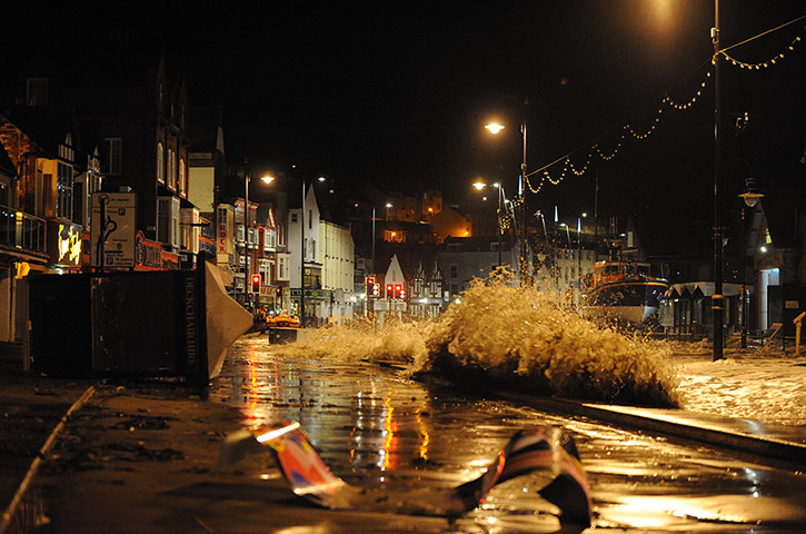 UK weather : Debris litters the road after the tidal surge stuck Scarborough