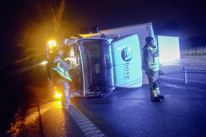 Storm Xaver in Europe: Rescuers stand by an overturned truck on the motorway north of Ystad, southern Sweden