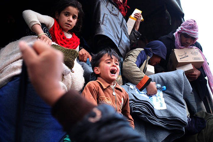 20 Photos: Syrian refugees board a Jordanian military vehicle