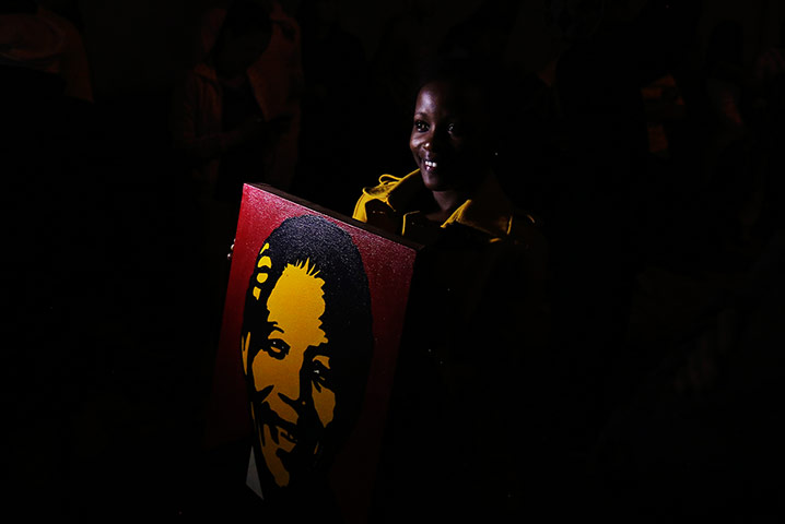 20 Photos: A woman holds a poster of Mandela