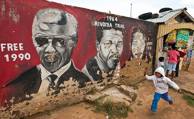 Celebrate Nelson: Children walk past a mural depicting Nelson Mandela