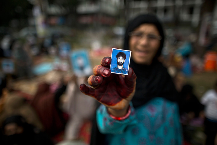 Weekend in pictures: Islamabad, Pakistan: Naseeb Zada holds up a photograph of her missing son B