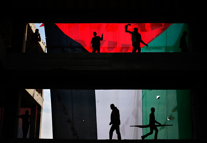 Weekend in pictures: Gaza City, Gaza Strip: Supporters stand in front of a giant Palestinian fla