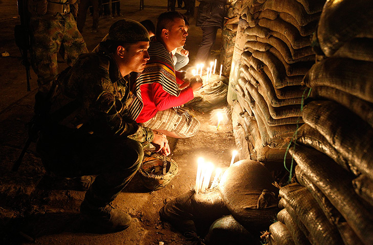 Weekend in pictures: Inza, Columbia: A soldier lights candles to honour comrades who were killed