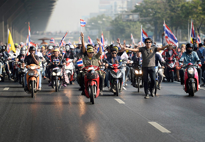 Thailand protests: Protesters ride their motorbikes on a main road in Bangkok