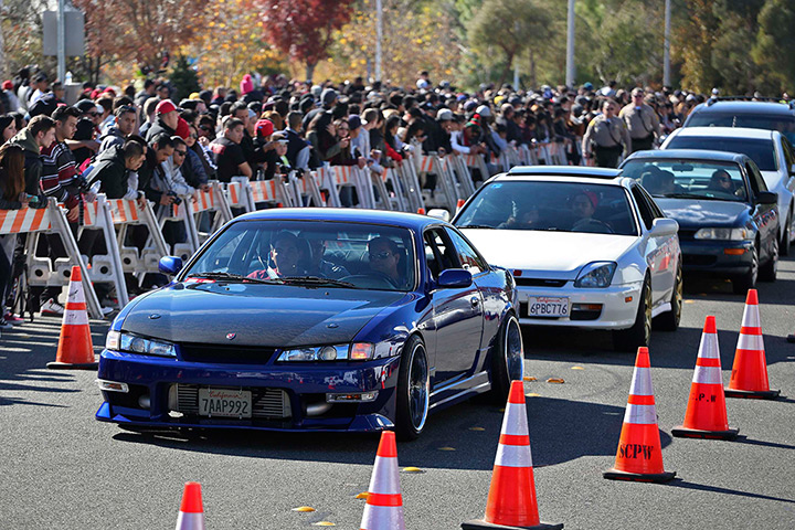 Paul Walker memorial: Vehicles are driven past a crowd attending an unofficial memorial event in 