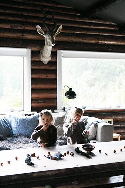 Homes - Nordic: Lounge with children sitting behind table and deer's head