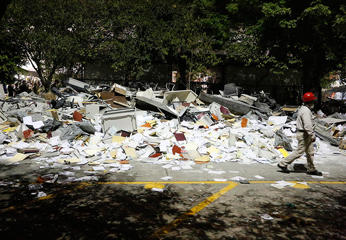 Mexico explosion: A worker walks past debris piled outside