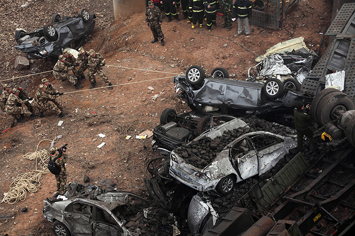 24 hours in pictures: Chinese paramilitary policemen pull at car wreckage at the accident site